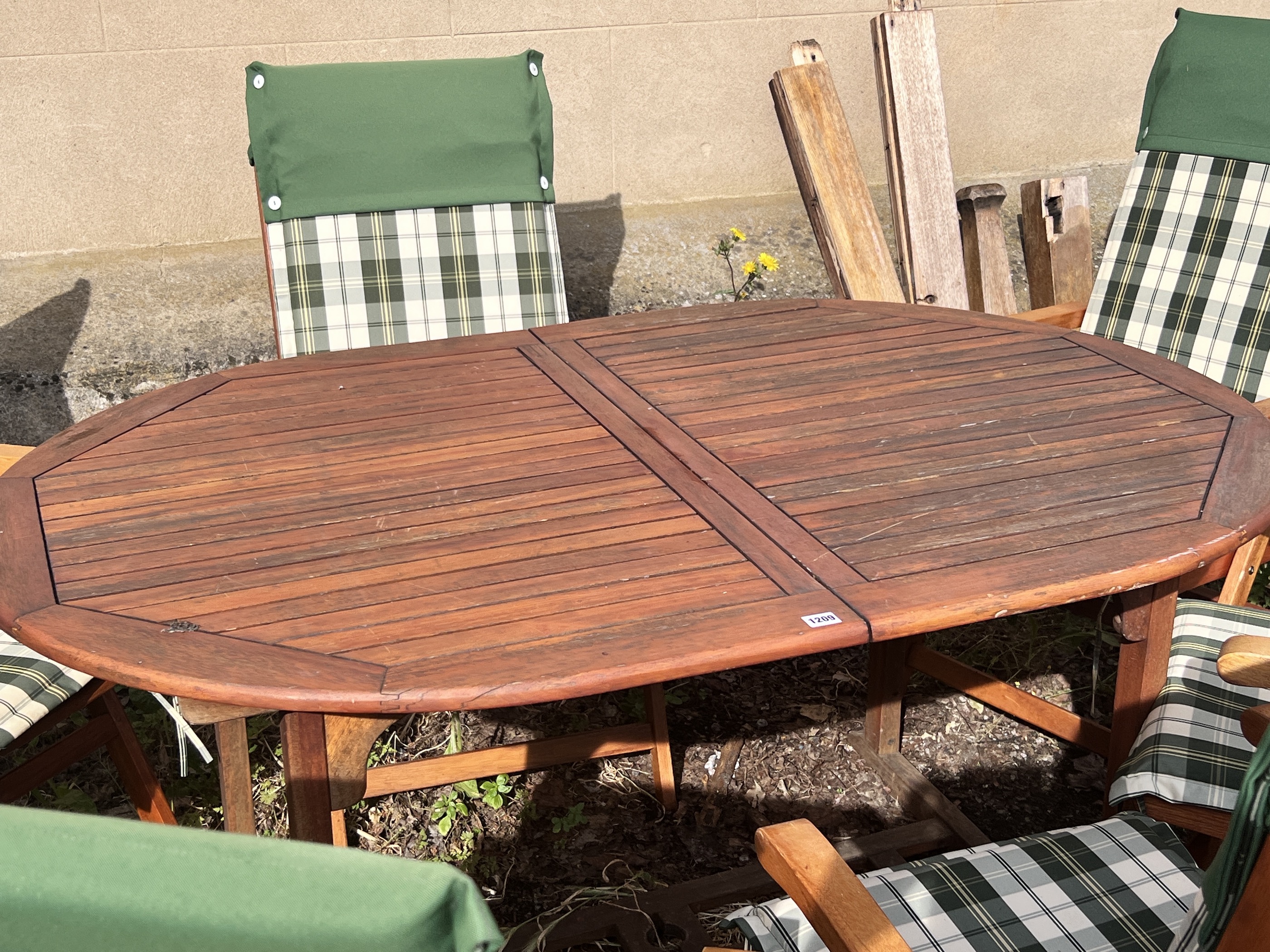 A stained teak extending garden table, length 150cm, depth 100cm, height 76cm, together with six Deuba teak folding garden chairs with cushions